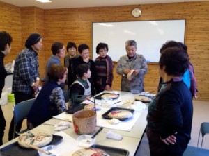 柿渋塗りの方法を説明する佐藤美喜子さん(写真奥)